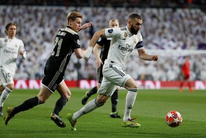 El delantero francés del Real Madrid, Karim Benzema, se lleva el balón perseguido por Frenkie de Jong, del Ajax.