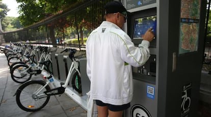 Un ciudadano trata infructuosamente de utilizar BiciMad junto al Retiro.