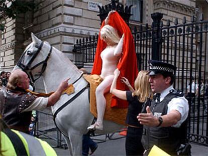 Manifestación de un grupo de trabajadores, encabezados por una estatua disfrada de Lady Godiva, cerca de la residencia del primer ministro británico, Tony Blair. PLANO MEDIO - ESCENA