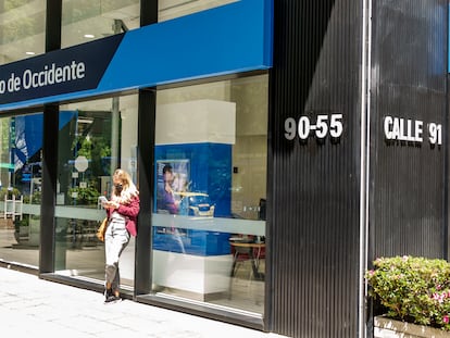 Una mujer usa su teléfono afuera de una sucursal del Banco de Occidente, en Bogotá (Colombia).