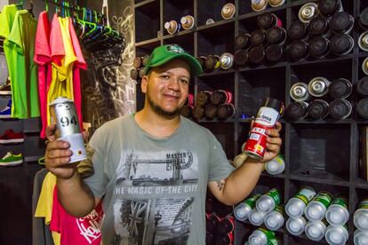 Ciro Censura, también fundador de Casa Kolacho, muestra algunos de los aerosoles que están a la venta en la tienda que administran en el local. También venden cuadernos, ropa, calzado y discos. 