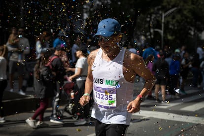 Corredores son cubiertos de confeti durante su paso por Paseo de la Reforma.