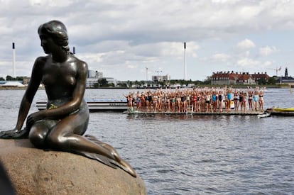 Un centenar de jóvenes se dispone a saltar y formar el número "cien" en el agua, para recordar el 23 de agosto de 1913 en que la estatua de La Sirenita se inauguró en la bahía de Copenhague, en Langelinie