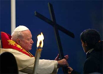 Una joven madrileña entrega la cruz a Juan Pablo II en memoria de las víctimas del 11-M.