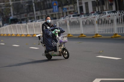 Un hombre con una máscara protectora, circula en una bicicleta, en la ciudad de Wuhan, el 29 de enero.