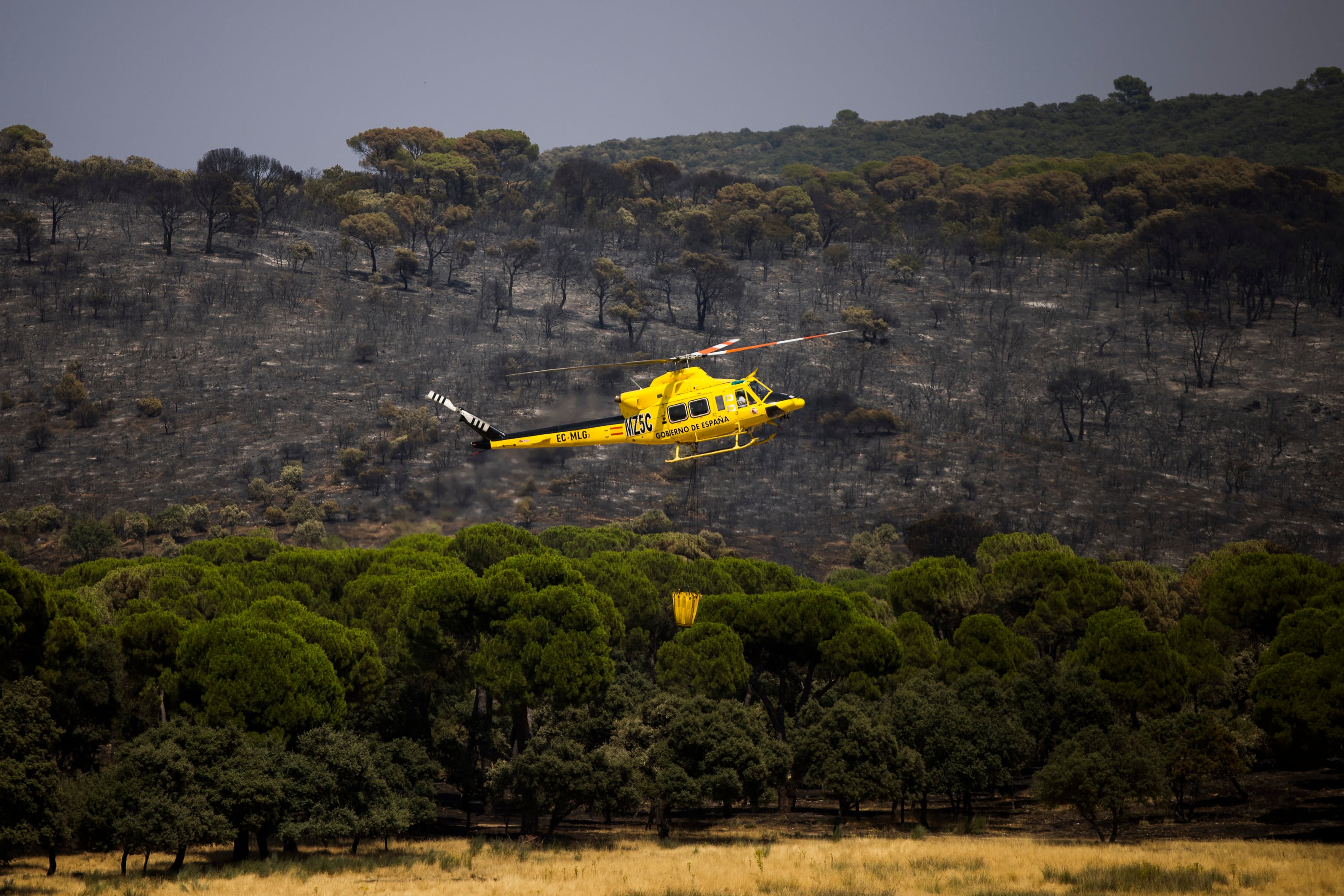 Un helicóptero trabaja en el incendio forestal del Villa del Prado (Madrid), este martes. 