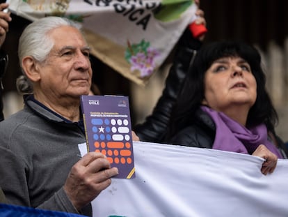 Un hombre sostiene un ejemplar de la propuesta de nueva Constitución durante un acto en Santiago de Chile.