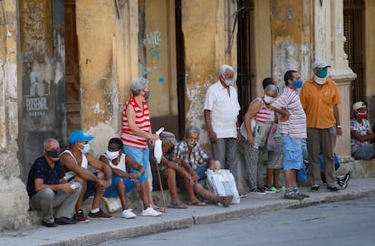 Várias pessoas esperam sua vez para comprar alimentos na sexta-feira em Havana.