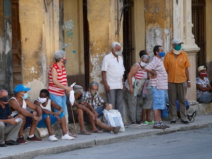 Várias pessoas esperam sua vez para comprar alimentos na sexta-feira em Havana.