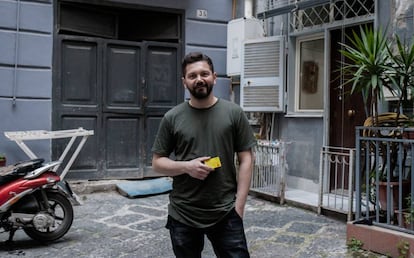 Davide Gianicelli, de 29 años, muestra la tarjeta de la Renta en la puera de su casa del centro de Nápoles.