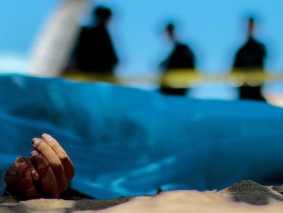 Forenses observan el cuerpo de un hombre muerto en Acapulco, en 2016.