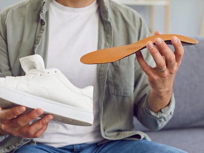 Un hombre metiendo las plantillas en su calzado.
