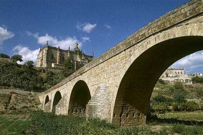 El río Alagón desvió su cauce tras una crecida invernal a mediados del siglo XVII, dejando sin agua el puente medieval de Coria (de 1518, en la foto). Al fondo, la catedral de la localidad, de estilo gótico-plateresco.