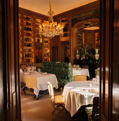 Un banco tapizado en verde malaquita preside el comedor en la antigua biblioteca.