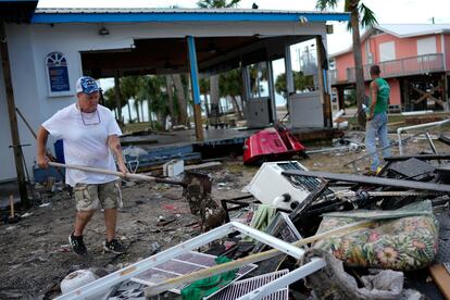 An employee dumps out a shovel full of mud as businesses start cleaning up after Idalia, in Horseshoe Beach, Florida, on Aug. 31, 2023.