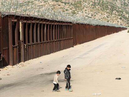 Niños migrantes juegan cerca del muro mientras esperan a ser transportados por la Patrulla Fronteriza, en Jacumba Hot Springs, California (EE UU) este 4 de junio.