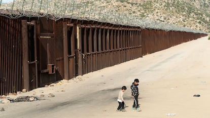 Niños migrantes juegan cerca del muro mientras esperan a ser transportados por la Patrulla Fronteriza, en Jacumba Hot Springs, California (EE UU) este 4 de junio.