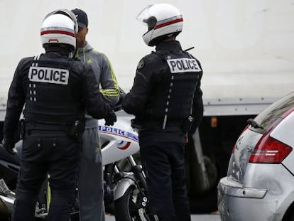 Policial francesa revista um homem no centro de Paris.