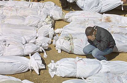 Un hombre llora entre las bolsas que contienen cadáveres recuperados de los escombros, en el hospital del campo de refugiados de Yenín.