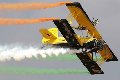 Un avión del equipo escandinavo de acrobacias deja una estela con la bandera india mientras realiza una exhibición aérea durante la inauguración de Aero India-2017 en la base de Yelahanka en Bangalore (India).