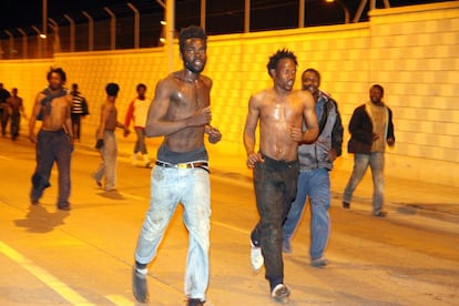 Un grupo de inmigrantes corren después de haber logrado cruzar a Melilla por la zona de vallado simple del a frontera con Marruecos, en Arroyo de Beni-Enzar.