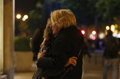 Dos mujeres se abrazan tras el tiroteo en los aledaños de los Campos Elíseos en París, Francia.