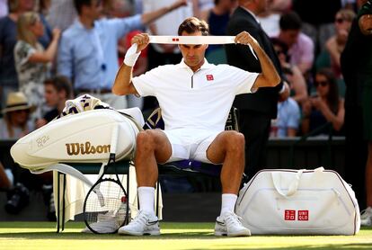 El tenista de Basilea, Roger Federer, se coloca la cinta del pelo, en un descanso del partido.