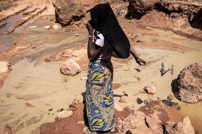 Una mujer calienta una estufa de leña en la mina de oro de Karakaene. La deforestación y la degradación del suelo son las consecuencias medioambientales más visibles de las explotaciones mineras. “La minería artesanal y a pequeña escala implica a menudo la tala excesiva de madera para sostener los pozos mineros y satisfacer las necesidades de vivienda y calefacción de los trabajadores”, anota el Instituto de Estudios de Seguridad de África, en un estudio sobre el caso senegalés.