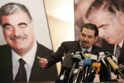 Hariri, flanqueado por el retrato de su padre asesinado, responde a las preguntas de los periodistas tras su triunfo electoral.