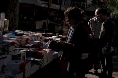 Una lectora fullejant un llibre en una parada a Barcelona.