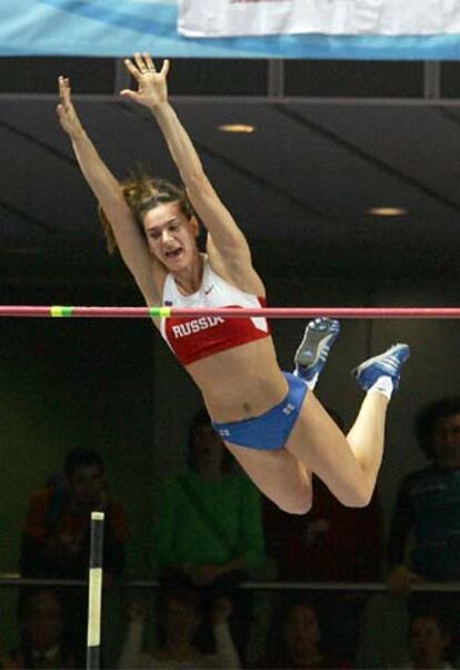 Yelena Isinbayeva suelta la pértiga y gira  sobre el listón.