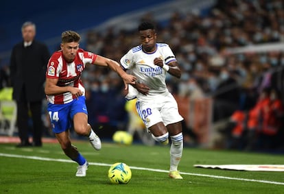 Vinicius se disputa el balón con Marcos Llorente en el partido del Real Madrid contra el Atlético.