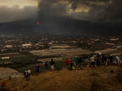 Um grupo de curiosos contempla a erupção do vulcão em La Laguna, na terça-feira.