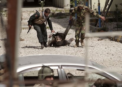 Un soldado del ejército afgano y un policía arrastran el cuerpo sin vida de un terrorista suicida, después del ataque de los talibanes a la estación de policía de Jalalabad, Afganistán.