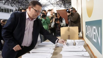 El candidato de IU a la Presidencia del Principado de Asturias, Jesús Iglesias, elige su papeleta electoral en un colegio de Gijón.