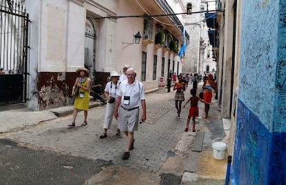 US tourists walks outside the Bodeguita del Medio Bar frequented by the late American novelist Ernest Hemingway in Old Havana, Cuba