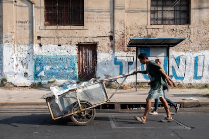 Dos hombres recogen cajas de cartón de la basura para reciclar en la ciudad argentina de Rosario.