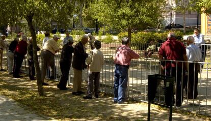 Un grupo de jubilados se reunen en un parque madrileño para jugar a la petanca.