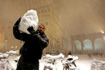 Un hombre acarrea una enorme bola de nieve en la plaza de la Señoría, en la ciudad italiana de Florencia.