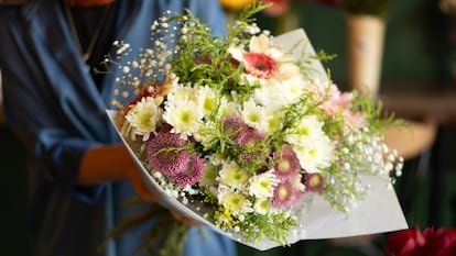 Una mujer sosteniendo un ramo de flores.