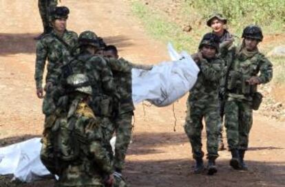 Militares colombianos portan el cuerpo de un soldado asesinado por las FARC.