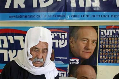 Según los sondeos, el partido de Sharon, Kadima, se haría con entre 33 y 36 escaños, por delante de los laboristas, que obtendríam entre 17 y 21. El Likud de Netanyahu sería la tercera fuerza, con entre 12 y 15 escaños. Aún quedarian 28 en juego, ya que un 22% del electorado aún no ha decidido a qué fuerza política votar, y sólo un 65% está seguro de que acudirá a las urnas. En la imagen, un israelí druso pasea entre los carteles electorales de la ciudad israelí de Mughar.