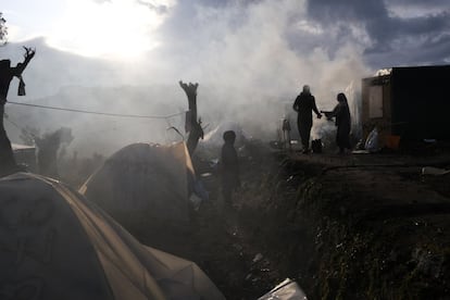 Migrantes fuera de sus tiendas improvisadas fuera del perímetro del hacinado campamento de refugiados de Moria, en la isla de Lesbos (Grecia), el martes 28 de enero.