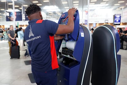 Un empleado revisa una máquina de facturación en el  aeropuerto de Orly en París (Francia), este viernes. 