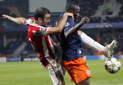 Torossidis disputa el balón con Utaka, del Montpellier.