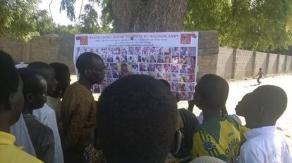 Diverses persones observen les fotos de sospitosos de formar part de Boko Haram.