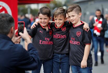 Unos niños se hacen una foto con la camiseta de su equipo, el Arsenal, antes de un partido de la Premiere League entre el Arsenal y el Swansea City en Londres. 