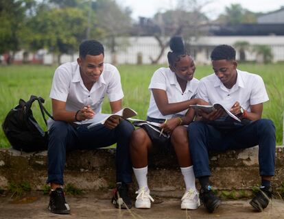 Varios estudiantes de bachillerato observan los libros antes de entrar a las aulas, en La Habana (Cuba).