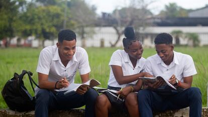 Varios estudiantes de bachillerato observan los libros antes de entrar a las aulas, en La Habana (Cuba).