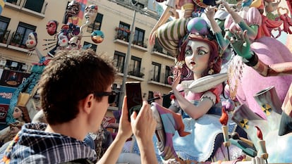 Visitantes a las Fallas de Valencia recorren y sacan fotografías de los monumentos falleros repartidos por toda la capital.